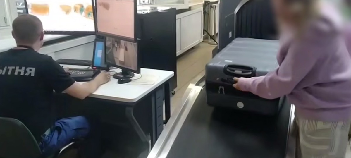 Беларуский таможенник проверяет чемодан женщины. Скриншот видео ГТК