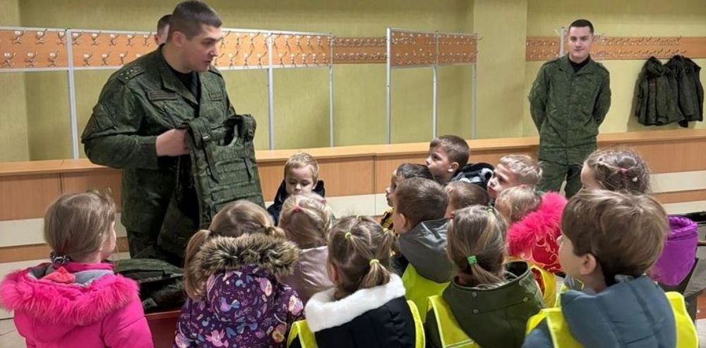 Военный показывает группе детей дошкольного возраста военное обмундирование в 72 ОУЦ Борисова